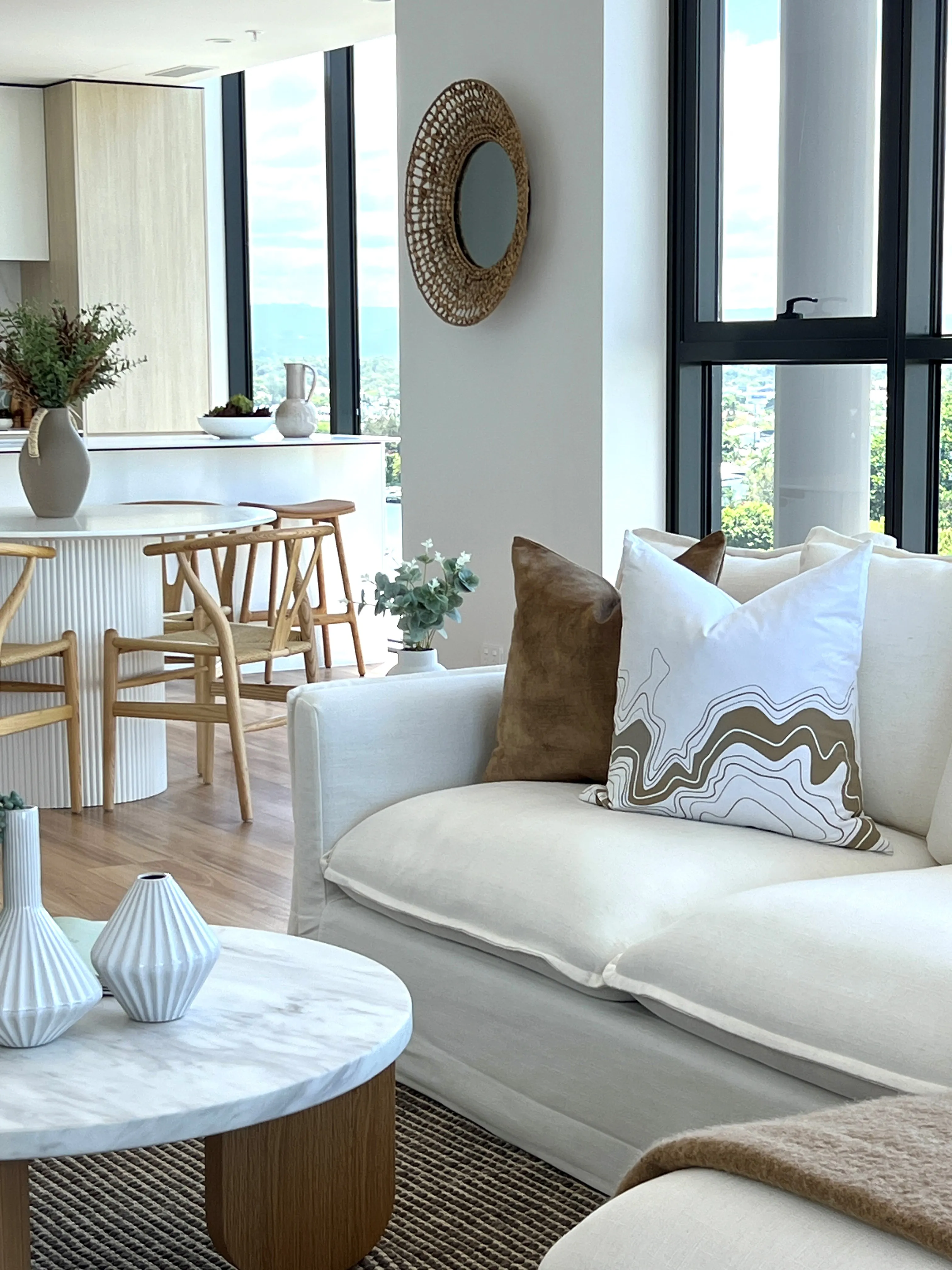 Living area detail with marble coffee table, fluted white vases and earth-toned agate cushion